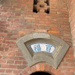 簷廊右次間採拱型廊門上塑「百福」，開通寶型磚砌氣窗