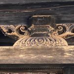 斗座以文印書卷為底座，雙側襯托如意草尾纹，下承壽樑、上頂方斗，將剛硬的結構轉化為充滿人文氣息的木雕藝術