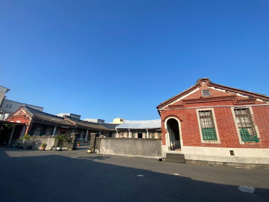一進正身七開間，左右護龍五開間格局，左右對稱開磚砌圓拱廊門，設梯級，高低層次的視覺營造出活潑的畫面